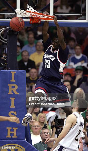 Denham Brown of the Connecticut Huskies slams the ball over Chris Quinn of the Notre Dame Fighting Irish on January 30, 2005 at the Joyce Center at...