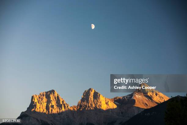 evening light on the three sisters - canmore stock pictures, royalty-free photos & images