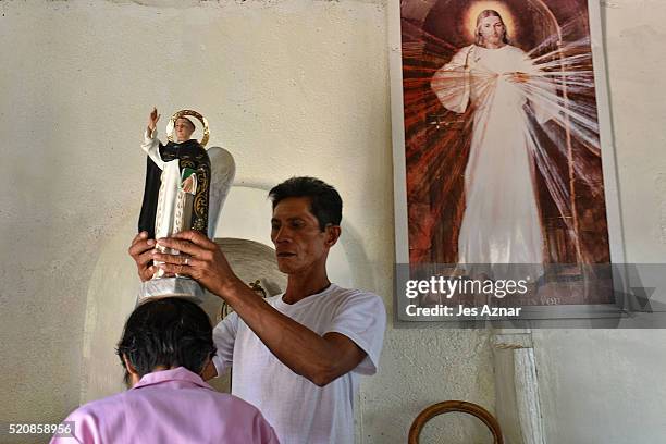 Resident asks for blessing from a religious image inside the chapel of a farming community in Antipas on April 6, 2016 in Cotabato, Mindanao,...