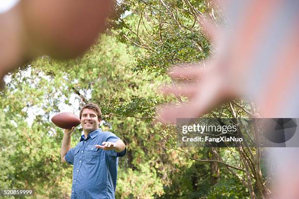 man tossing football - throwing football stock pictures, royalty-free photos & images