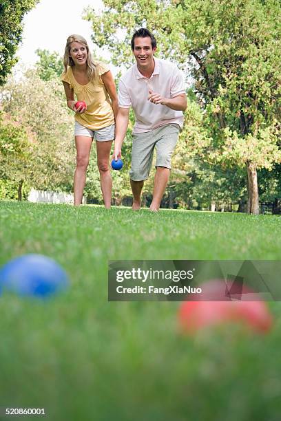 man and woman outside playing bocce ball - bocce ball stock pictures, royalty-free photos & images