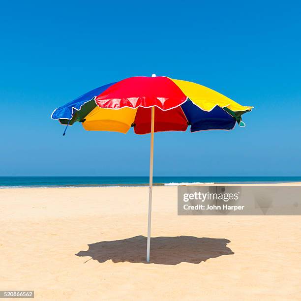 beach umbrella, benota beach, sri lanka - beach umbrella sand stock pictures, royalty-free photos & images