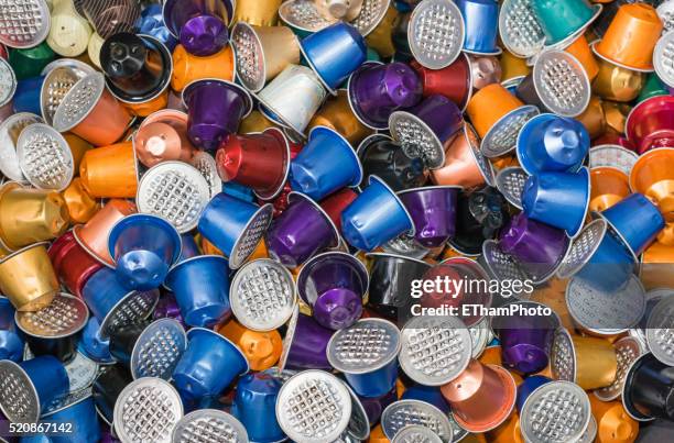 garbage heap of colourful empty nespresso disposable espresso capsules - capsule café photos et images de collection