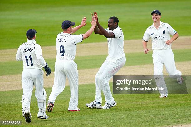 Keith Barker of Warwickshire celebrates with his teammates after getting the wicket of Sean Ervine of Hampshire during day four of the Specsavers...