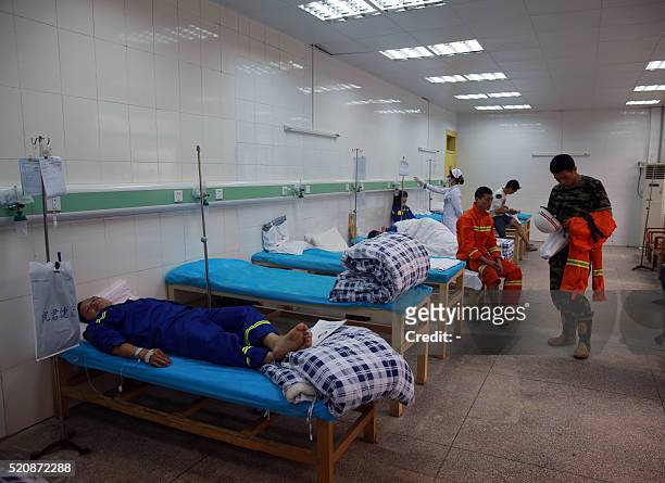 Rescuers and workers who were wounded in a crane collapse accident, receive medical treatment at a hospital in Dongguan, south China's Guangdong...