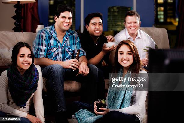 multi-ethnic young adult friends hanging out, downtown apartment. watch tv. - media entertainment night 2014 stock pictures, royalty-free photos & images