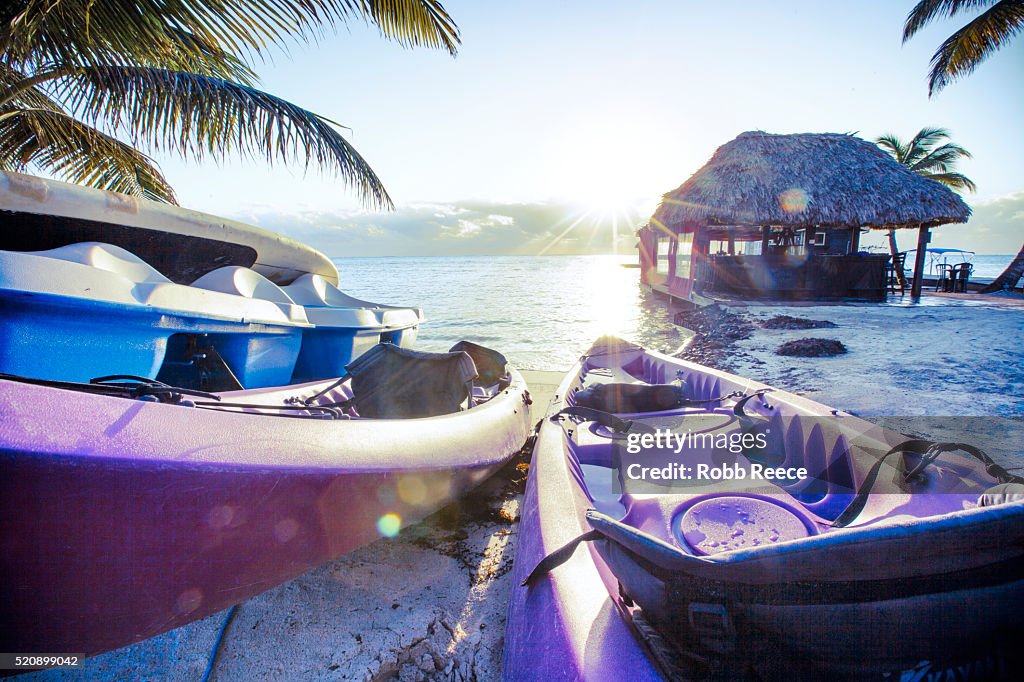 Kayaks on a resort beach in Belize at sunrise