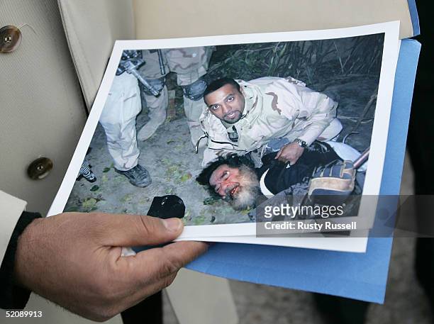 Photo of the capture of Saddam Hussein, subdued during his capture by U.S. Special Forces translator Samir , is displayed by a companion of Samir...
