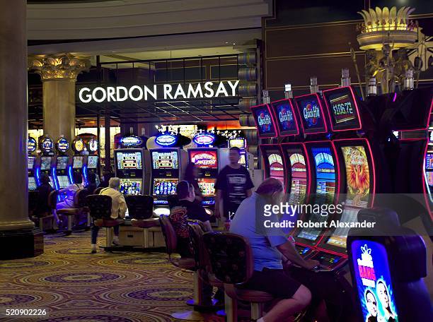Guests play slot machines and other gaming devices at Caesars Palace Las Vegas Hotel and Casino located along the Las Vegas Strip in Las Vegas,...
