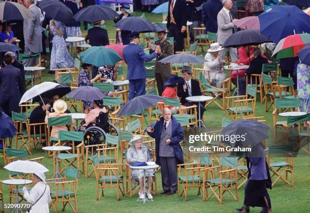 Guests Sheltering Under Umbrellas During A Garden Party At Buckingham Palace Circa 1990s