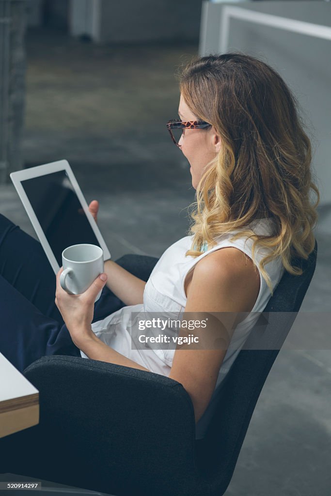 Businesswoman using digital tablet and drink coffee.