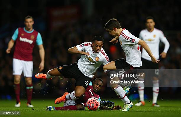 Anthony Martial and Ander Herrera of Manchester United challenge Michail Antonio of West Ham United during The Emirates FA Cup, sixth round replay...