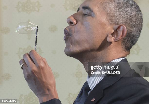 President Barack Obama blows a bubble using a bubble wand created with a 3D printer as he tours the 2016 White House Science Fair in the Blue Room at...