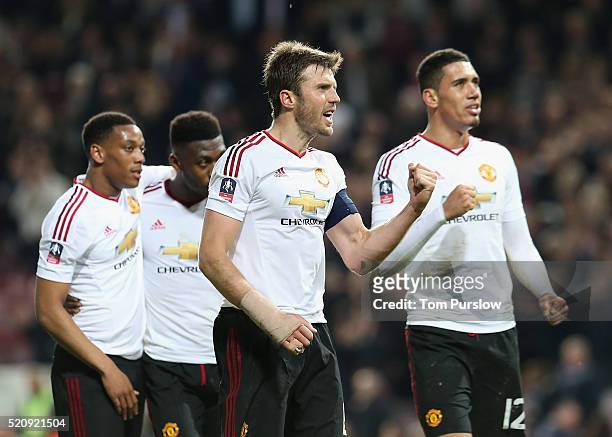 Michael Carrick and Chris Smalling of Manchester United celebrate after the Emirates FA Cup Sixth Round replay match between West Ham United and...