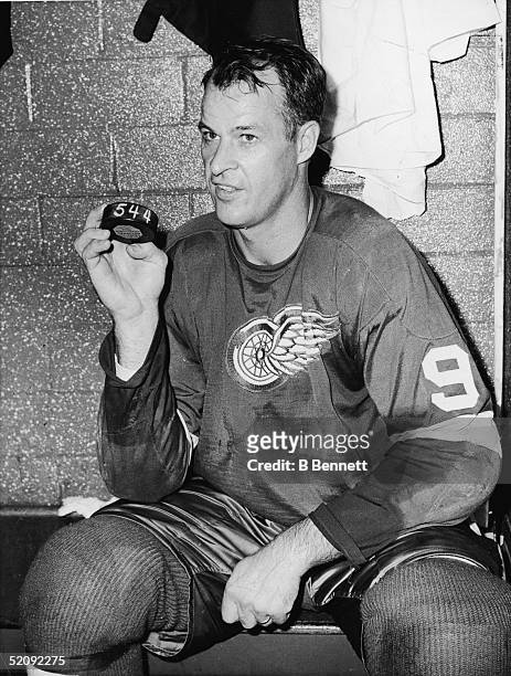 Gordie Howe of the Detroit Red Wings sits in the locker room and holds a hockey puck numbered 544 on October 24, 1963 at the Detroit Olympia Stadium...