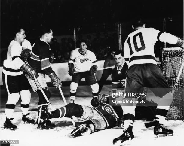 Scramble in front of the net during a game between the Detroit Red Wings and the Montreal Canadiens, mid 1950s. Players are, from left Red Wing...