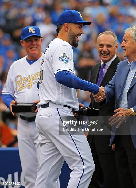 Eric Hosmer of the Kansas City Royals is congratulated by Royals owner David Glass after receiving his World Series Championship ring prior to a game...