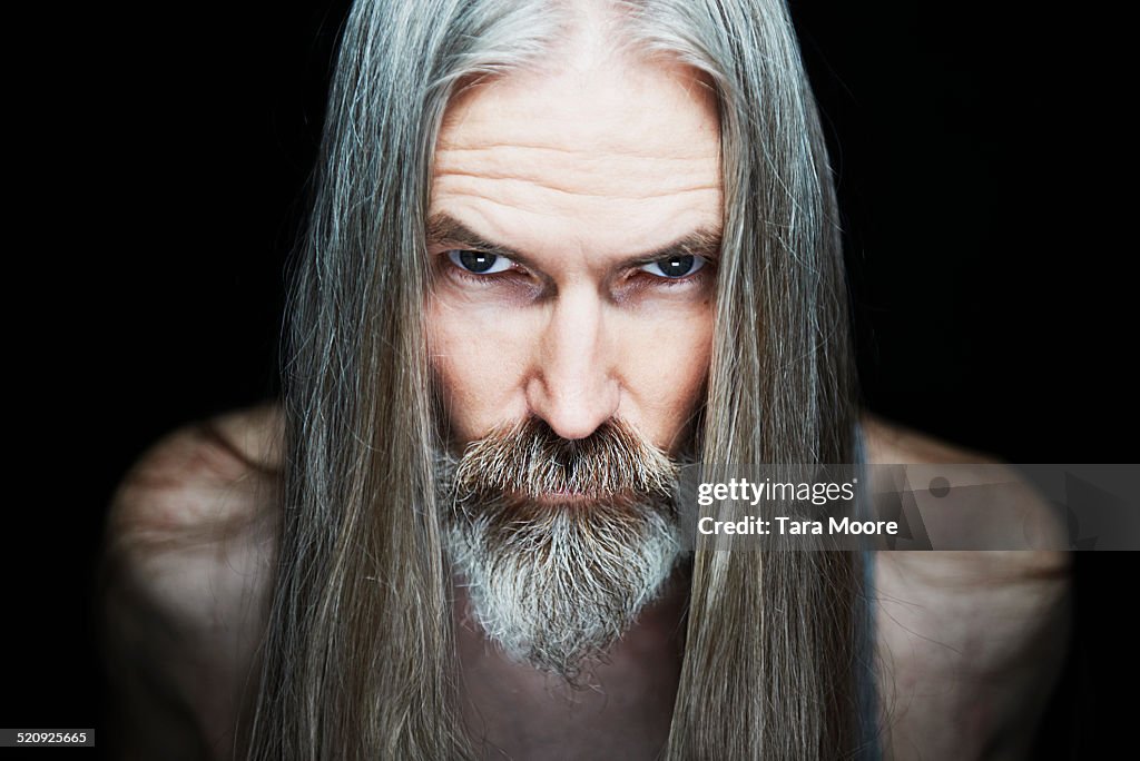 Mature man with long hair looking serious