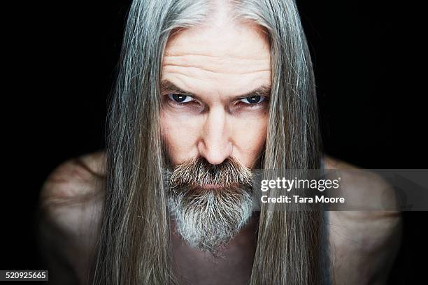 mature man with long hair looking serious - tara madden stock pictures, royalty-free photos & images