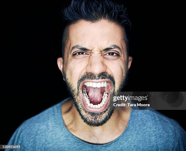 man shouting to camera - people on black background stock-fotos und bilder