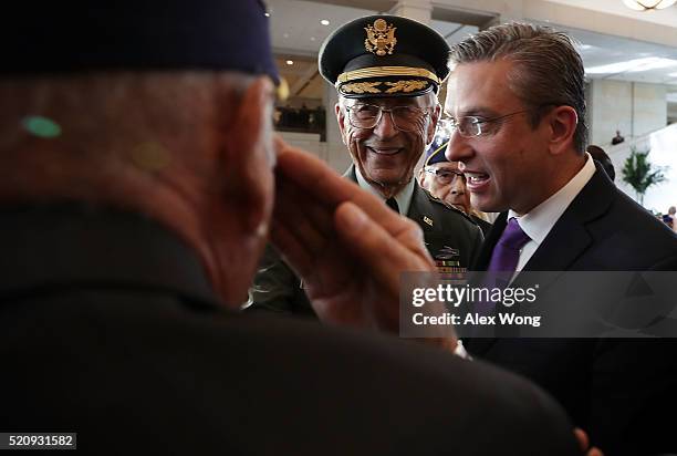 Veteran salutes retired U.S. Army Col. Manuel Siverio as Governor of Puerto Rico Alejandro Garcia Padilla looks on after a Congressional Gold Medal...