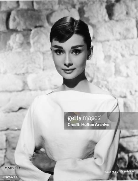 Portrait of Belgian-born American actress Audrey Hepburn ina white long-sleeved dress, mid 1950s.