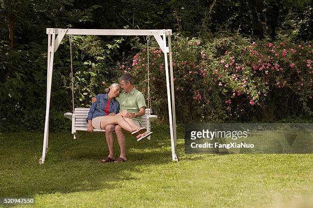 glückliches paar auf schaukel - pension stock-fotos und bilder