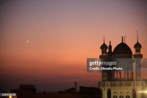 eid-al-fitr moon in sky and beautifully lit tomb of masjid in textile town of malegaon, maharashtra, india - crescent fotografías e imágenes de stock