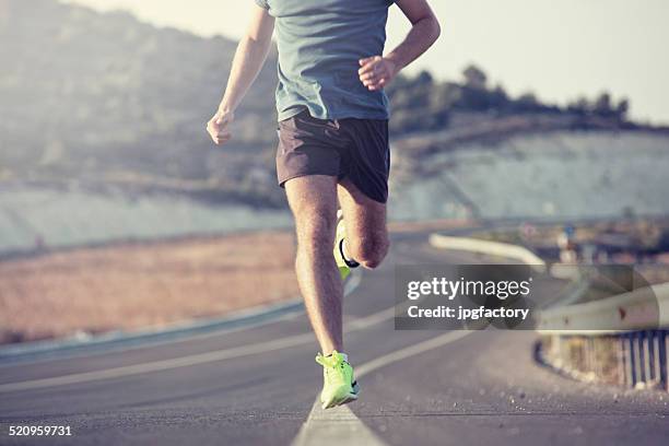 running outdoor on asphalt road - man full length stock pictures, royalty-free photos & images