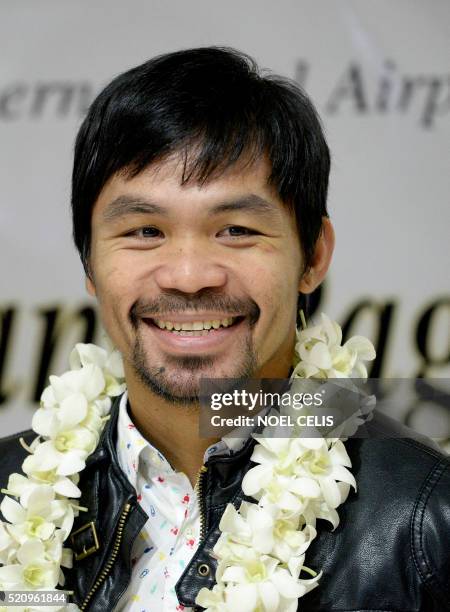 Filipino boxer Manny Pacquiao smiles as he arrives at the Manila International Airport in Manila on April 14, 2016. - Pacquiao defeated Timothy...