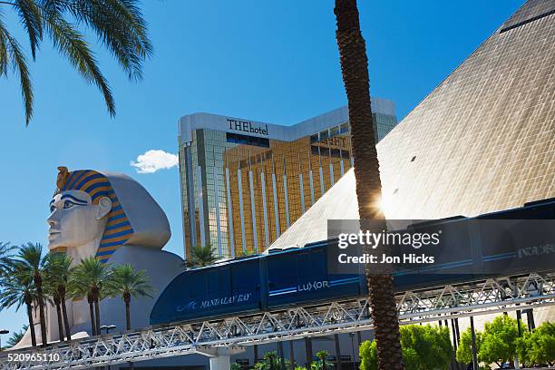 monorail passing beneath the luxor hotel and casino pyramid. - las vegas pyramid hotel stock pictures, royalty-free photos & images