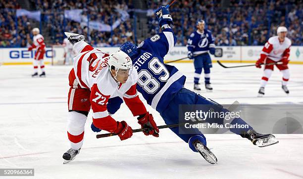 Andreas Athanasiou of the Detroit Red Wings is upended by Nikita Nesterov of the Tampa Bay Lightning during the first period in Game One of the...