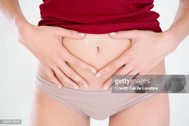 close-up hands on stomach - braga fotografías e imágenes de stock