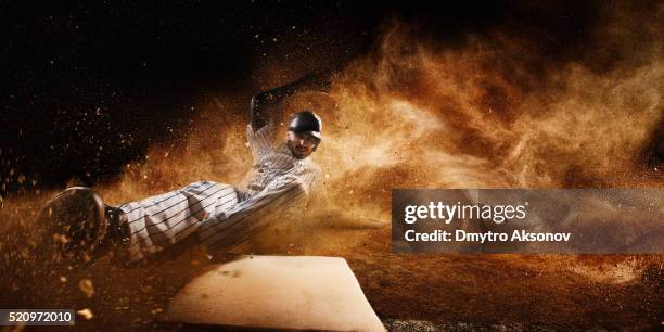 sliding on third base - baseball uniform stock pictures, royalty-free photos & images