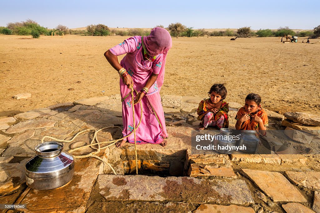 Indian woman drawing water from the well, desert, Rajasthan