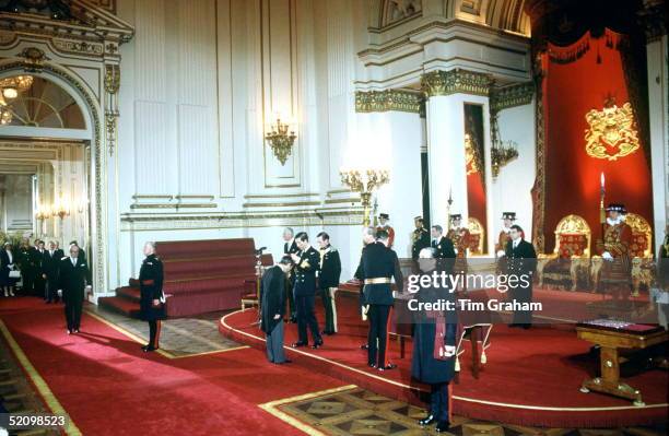 Prince Charles Conducting An Investiture In The Throne Room At Buckingham Palace. Yeomen Of The Guard Are In Attendance In The Throne Room.