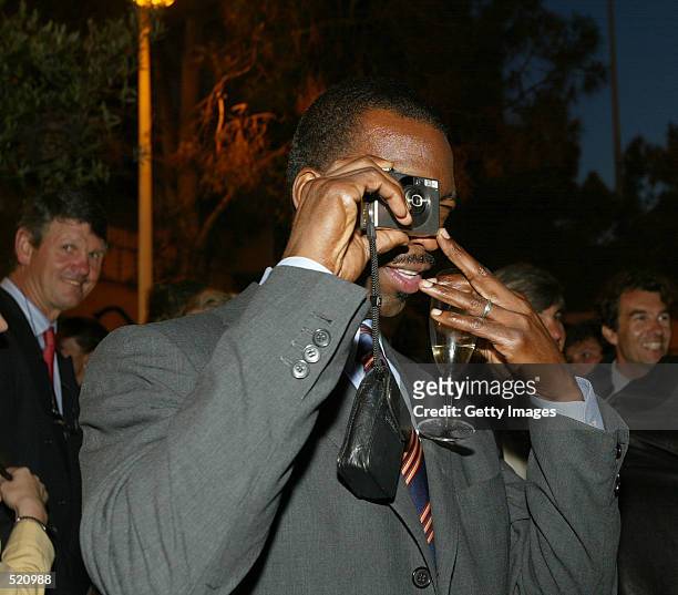 Monte Carlo, Monaco Michael Johnson taking a photo at a cocktail reception at the Yacht Club de Monaco in Monte Carlo on 13 May, 2002. The 3rd Annual...