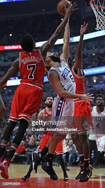 Kendall Marshall of the Philadelphia 76ers puts up a shot between Justin Holiday and Bobby Portis of the Chicago Bulls at the United Center on April...