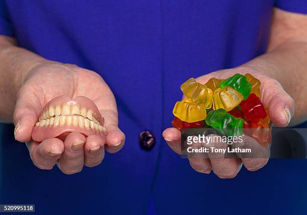 woman with dentures and gummi candy in her hand - jelly sweet stock pictures, royalty-free photos & images