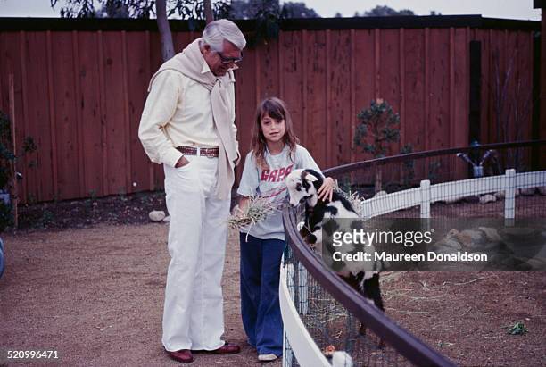 Actor Cary Grant with his daughter Jennifer and a goat, 1975.