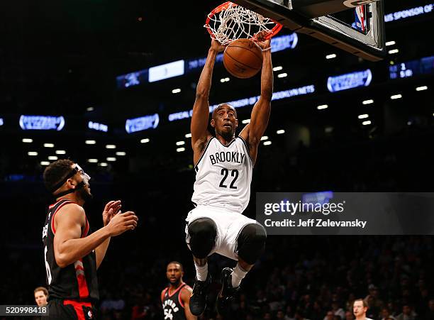 Markel Brown of the Brooklyn Nets dunks in front of Cory Joseph of the Toronto Raptors during their game at the Barclays Center on April 13, 2016 in...