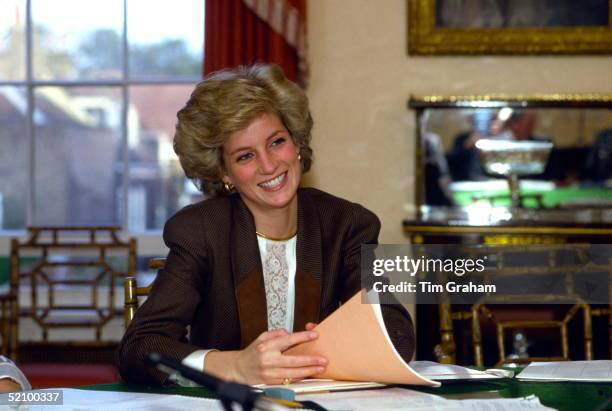 Princess Diana Holding Papers Sitting At Her Dining Room Table At Home In Kensington Palace, London And Taking Part In A Planning Meeting To...