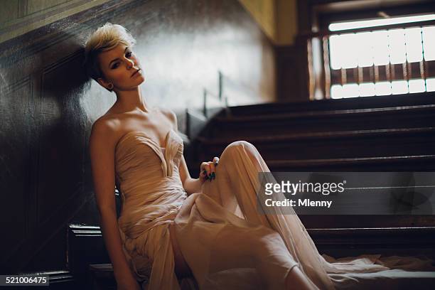 pensive woman in evening gown sitting on stairway - prom dress stock pictures, royalty-free photos & images