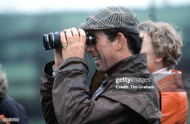 Prince Charles At The Fernie Hunt Cross Country Team Event Wearing Flat Cap And Looking Through Binoculars.