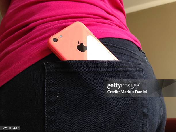 Pink iPhone 5c in a woman's black jeans back pocket