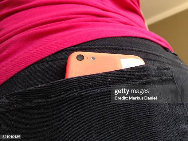 Pink iPhone in girl's black jeans back pocket