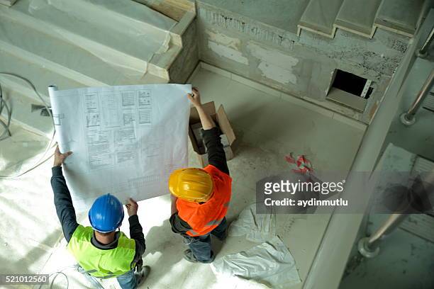 construction workers reading blueprints - construction contract stock pictures, royalty-free photos & images