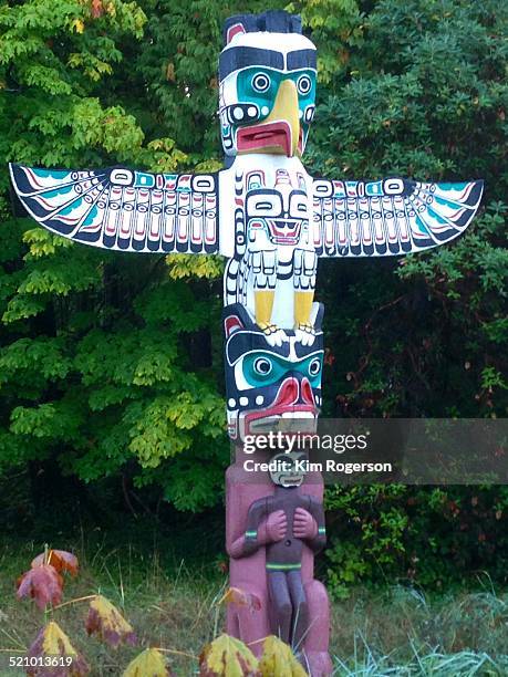 Totem pole of a thunderbird stands tall and at the ready in Stanley Park, Vancouver, BC, Canada.