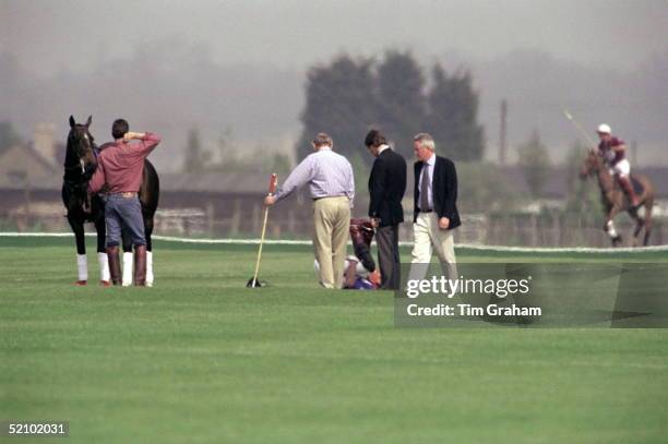 Prince Charles Lying Down Doing Strengthening Exercises For His Back Before Riding At Cirencester Polo Club.at Right Police Bodyguard Bob Fulton