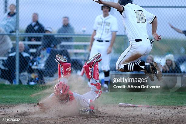 Trevor Howard of Rock Canyon Jaguars leaps over a tag attempt by Casey Opitz of Heritage Eagles on Wednesday, April 13, 2016. The game was delayed...